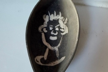 Afbeelding van decoratief zwart schaaltje met witte gezichtsafbeelding.  He