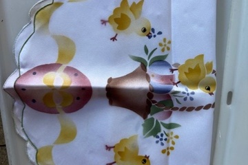 Afbeelding van wit tafelkleed of tafelloper met kuikentjes en bloemenprint.