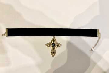 Afbeelding van Een zwarte fluwelen choker met een versierde kruis
